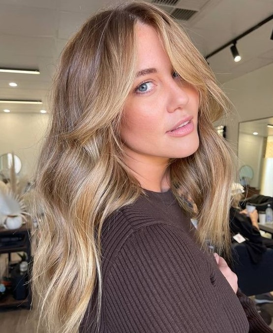 Long wavy light brown hair with blonde highlights and a chunky chin length money piece looks chic and beautiful