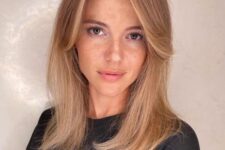 lovely medium-length caramel-colored hair with curtain bangs and blonde highlights is a cool idea for spring or summer