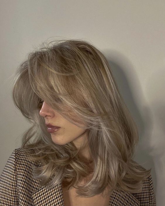 medium blonde hair with long curtain bangs, curled ends and some volume is amazing and looks effortlessly chic
