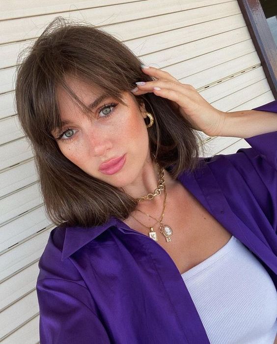 medium length brunette hair with wispy bangs looks chic, thick and beautiful and the bangs accent the eyes