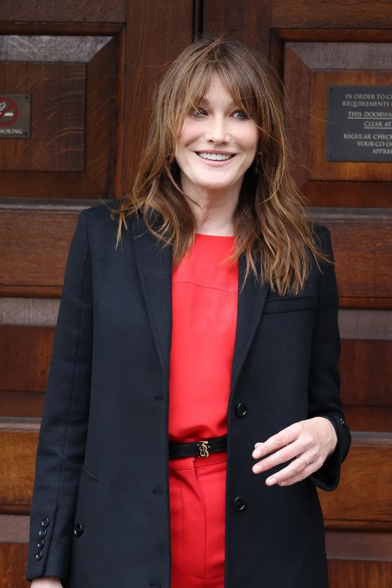 Carla Bruni rocking long brunette hair with caramel highlights and bottleneck bangs is amazing