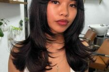 a black butterfly haircut with curtain bangs and curled ends is a cool and fresh idea to try on long or medium hair