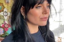 a black long wolf haircut with bottleneck bangs and waves down is a catchy and cool rock-style idea