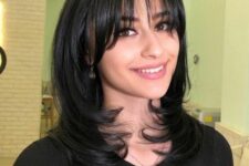 a black medium butterfly haircut with wispy to curtain bangs and curled ends is a lovely idea if you have shoulder-length hair
