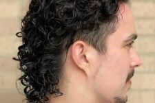 a black modern curly mullet with trimmed sides feels like the 80s and looks chic and stylish