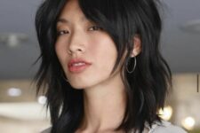 a black shaggy long bob with bottleneck bangs and a messy volume is a cool and bold idea