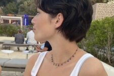 a black short mullet with a bit of waves and side bangs is close to a long pixie but looks more shaggy
