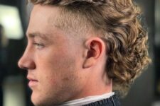 a blonde curly back mullet with a touch of fade and a top pushed back is a very bold style statement