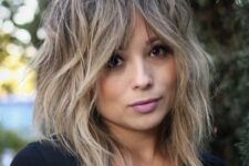 a blonde medium wolf cut with bottleneck bangs, messy texture is a cool and chic idea for anyone who loves blonde shades