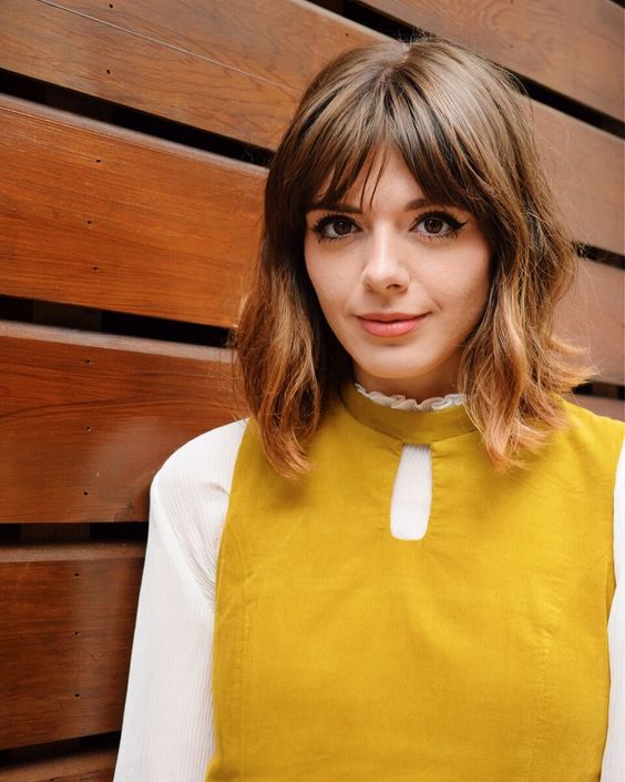 a brown long bob with bottleneck bangs and messy waves is a cool and pretty solution