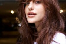 a burgundy long wolf cut with outgrown bangs and a messy volume is a cool idea inspired by the 70s