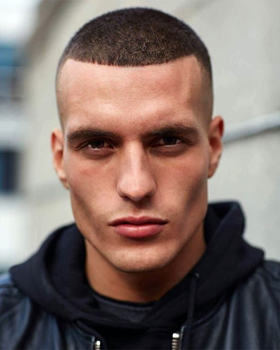 a buzz cut with a high fade and very sharp lines highlights the face features and gives a sharp look to them