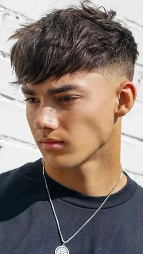 a catchy and bold mid fade haircut with a longer top, angular fringe and textured hair is a sexy idea