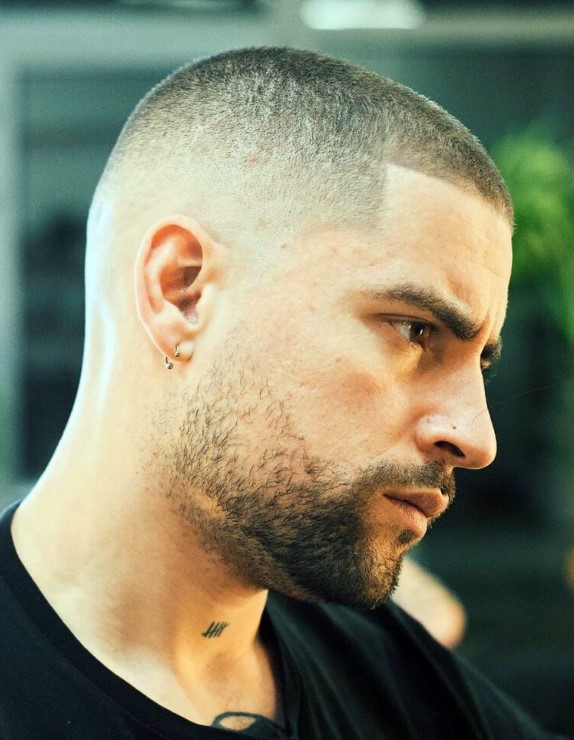 a classic buzz cut with faded sides, thin texture, a clean taper fade on the side and a modern beard