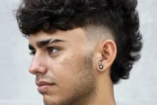 a curly mohawk with a fade is a super bold rock style with a lot of dimension and volume on top