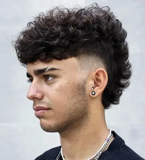 a curly mohawk with a fade is a super bold rock style with a lot of dimension and volume on top