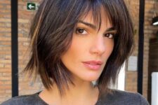 a dark brown shaggy long bob with caramel highlights and bottleneck and wispy bangs is a catchy and cool idea