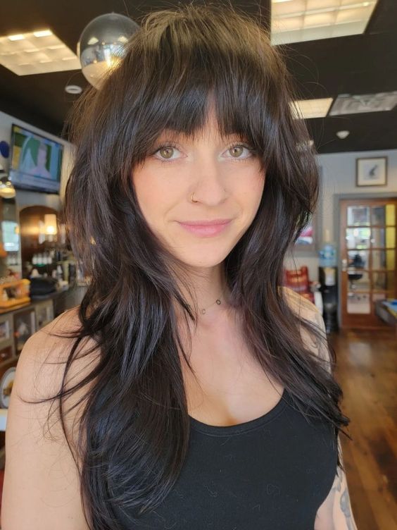 a dark brunette long wolf cut with blunt bangs, waves down is a lovely idea for those who wanna look esgy