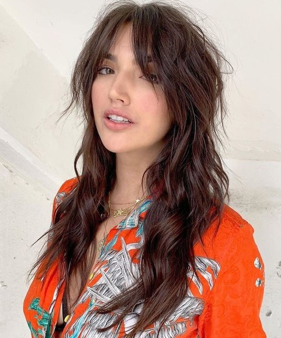 a dark brunette long wolf haircut with bottleneck bangs, waves down and volume is a lovely idea to rock