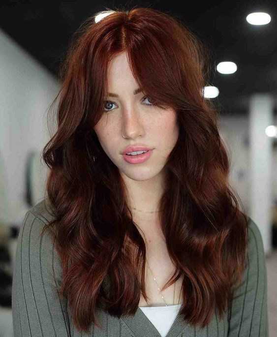 a deep ginger long butterfly haircut with bottleneck bangs and waves plus a lot of dimension is a cool and lovely idea