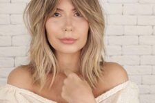 a dreamy blonde medium wolf cut with bottleneck bangs, messy waves is a chic and lovely idea