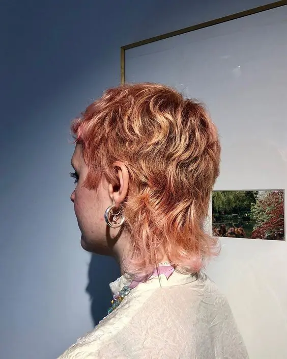 a ginger to pink short mullet with short bangs and waves is a catchy and bold idea to make a statement with