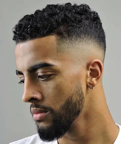 a high fade with short curly hair and line up is a cool idea for modern men who love a fresh and masculine style
