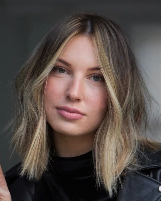 a long and messy brunette bob with a blonde money piece and an ombre touch is a cool and bright solution