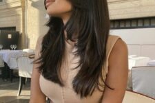 a long black butterfly haircut with long curtain bangs and curled ends is a very chic and catchy idea