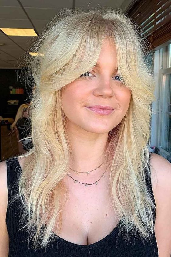 a long blonde wolf cut with bottleneck bangs and textured volume is a lovely idea that looks very actual
