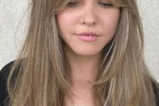a long bronde butterfly haircut with blonde highlights and curtain bangs is a lovely idea inspired by the 70s
