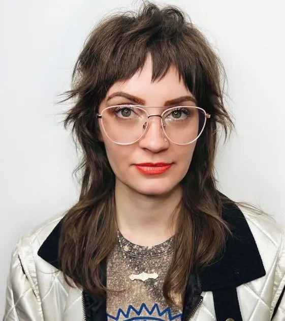 a long brown wolf cut with bottleneck bangs and layers is a catchy idea that feels retro