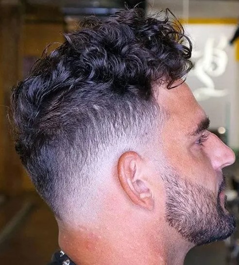 a long curly top with a low bald fade looks maculine, especially paired with a stylish beard