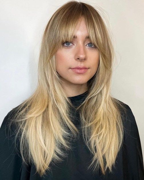 a long layered blonde haircut with bottleneck and curtain bangs is a very chic and beautiful solution
