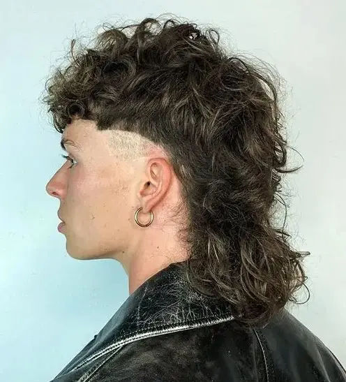 a long mullet wolf cut with shaved sides is a cool idea that shows off your curls is a cool and contrasting idea due to the shaved sides