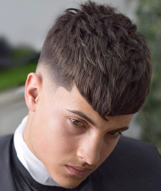 a longer Caesar haircut with a mid fade and an angular fringe looks great thanks to a lot of volume