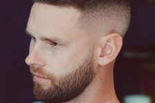a longer buzz cut with a high fade and a stylish beard are a great idea to look bold and edgy