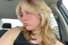 a medium blonde wolf cut with bottleneck and curtain bangs plus waves is a cool and trendy solution to rock