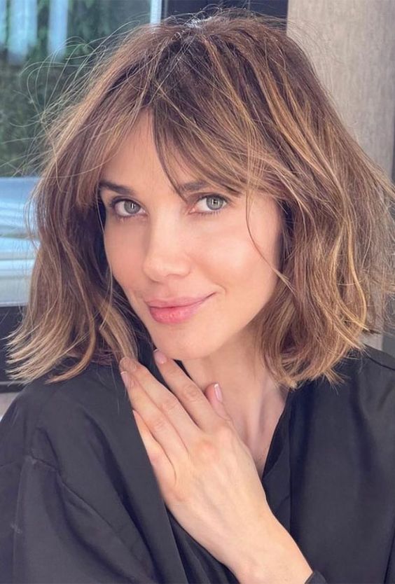 a medium-length caramel haircut with bottleneck bangs and messy waves is a lovely and very relaxed idea