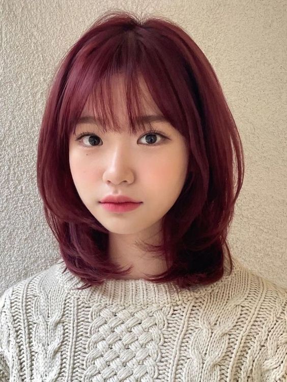 a medium length purple butterfly haircut with wispy bangs and curled ends looks super cute and delicate