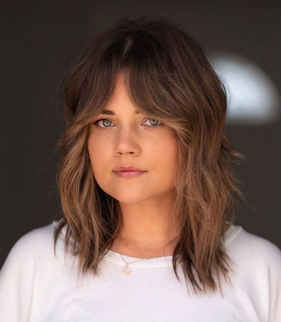 A medium length wolf cut with caramel balayage and bottleneck bangs plus a bit of messy waves is a lovely idea