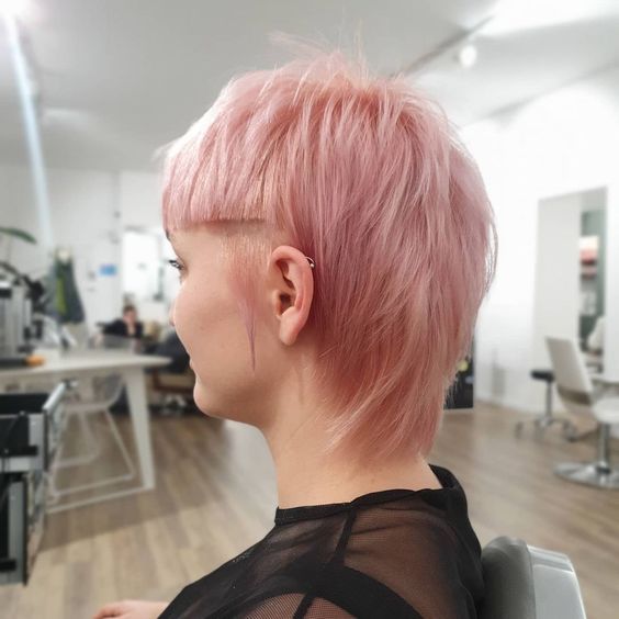 a pastel pink straight hair short mullet with sharp line bangs is a bold solution for those who are ready to make a statement