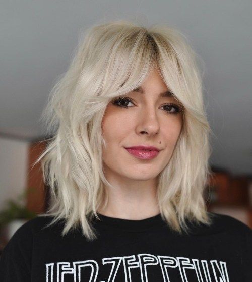 a platinum blonde medium wolf cut with bottleneck bangs and messy texture is a chic and bold solution