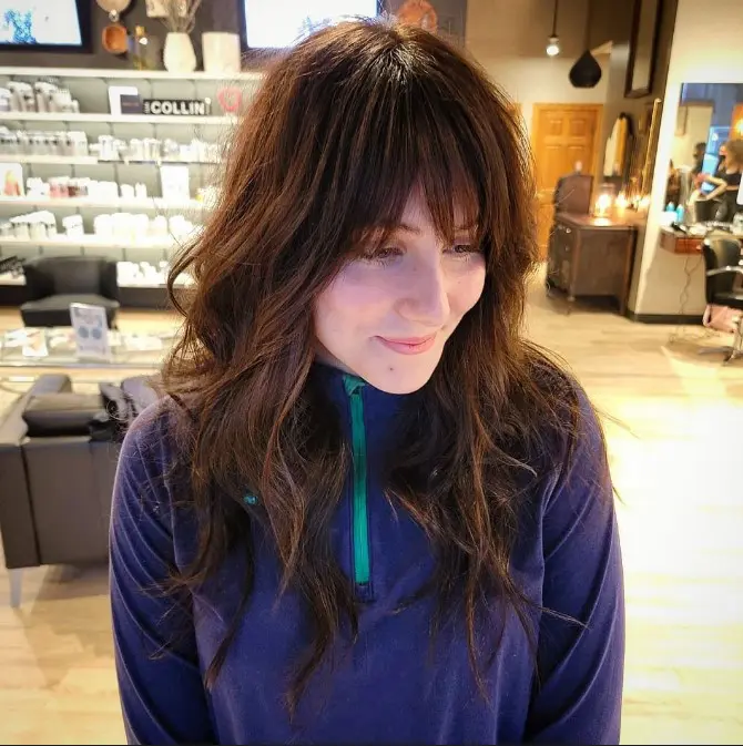 a rich brown long wolf cut with wispy bangs and waves is a cool and fresh look to try right now