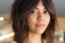 a shaggy dark brunette long bob with acramel ombre and bottleneck bangs plus a messy volume is wow