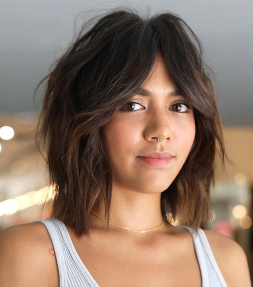 a shaggy dark brunette long bob with acramel ombre and bottleneck bangs plus a messy volume is wow