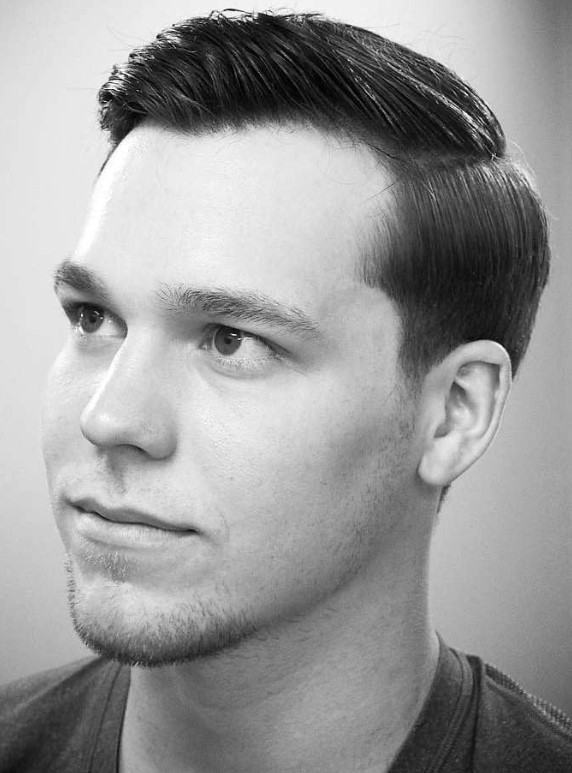 a simpel side part haircut with shorter sides that are slightly tapered, with hair slicked to the side