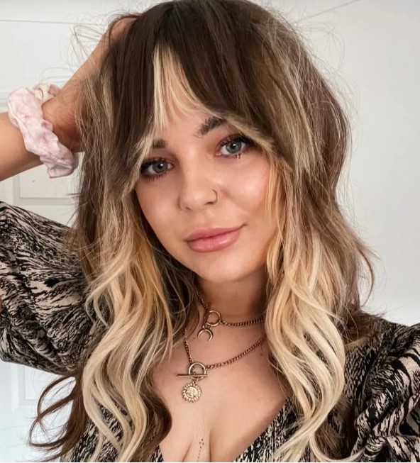 light brunette hair with blonde highlights and bottleneck bangs to frame the face perfectly