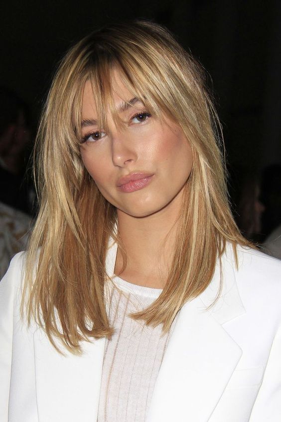 long and shiny blonde hair paired with bottleneck bangs for an ultimate look by Hailey Bieber