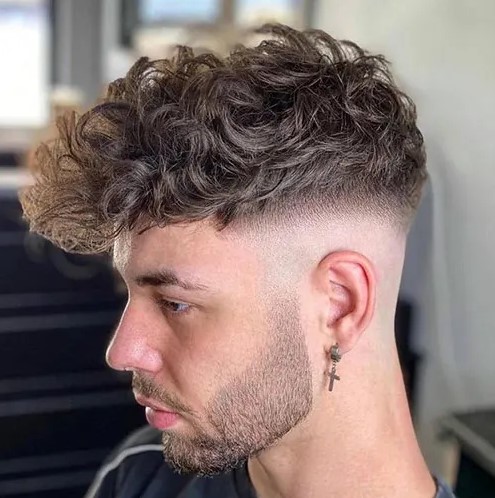 long curls with a mid skin fade look very contrasring and bold, and a beard addds interest to the look